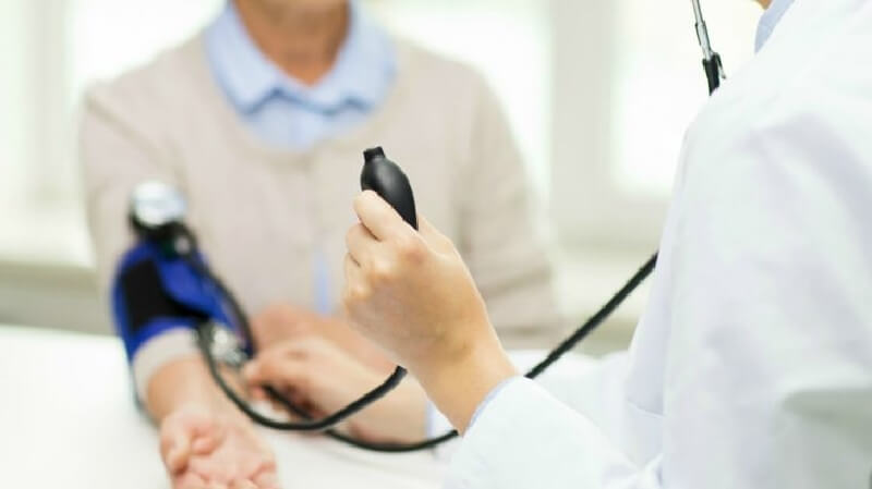 患者の血圧見る医者